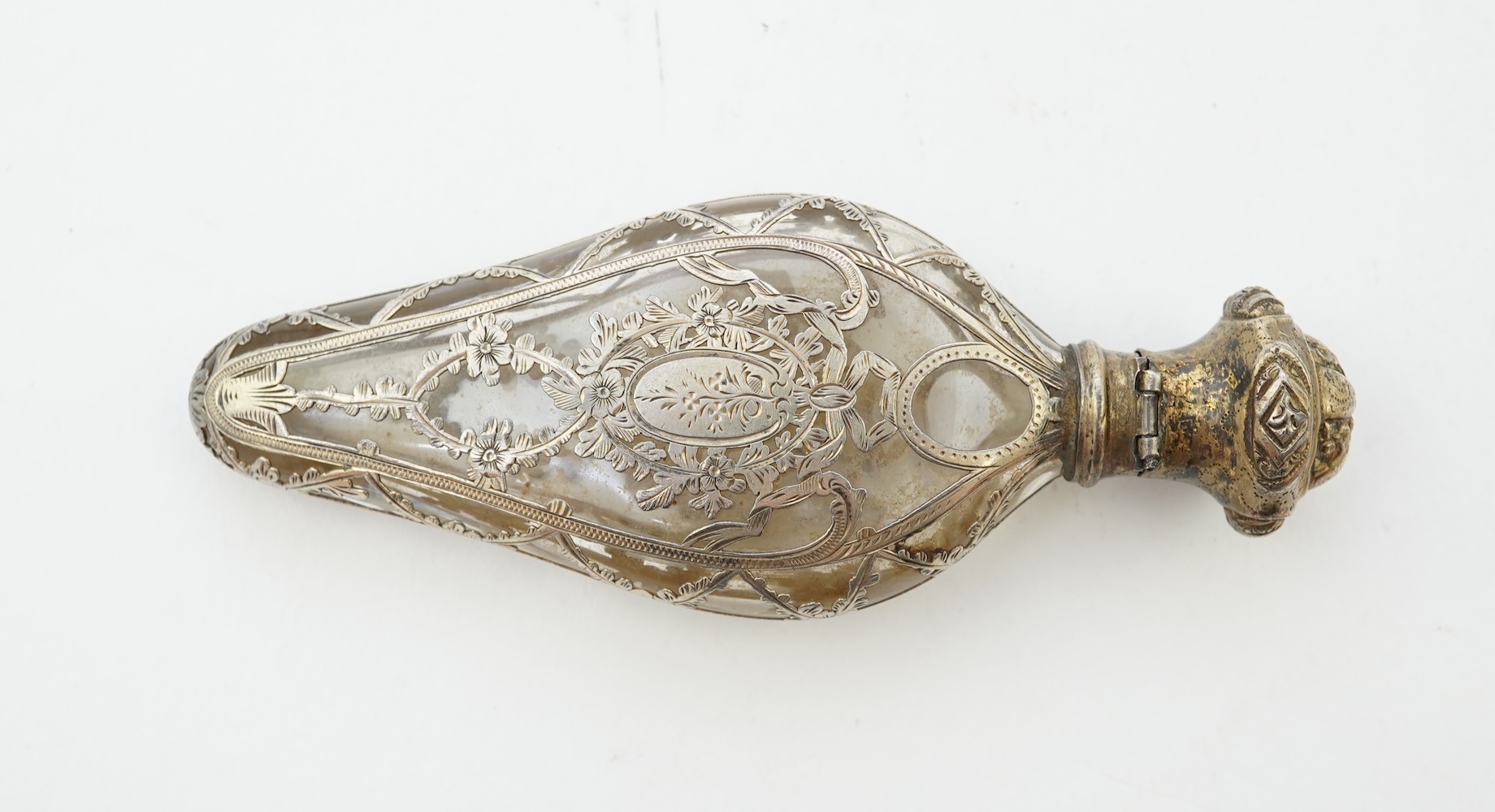 A late 19th century French parcel gilt white metal mounted and overlaid glass scent flask, with hinged cover and glass stopper